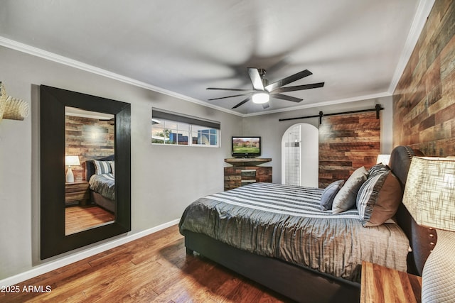 4610 N 14th Ave, Phoenix, AZ 85013 - bedroom with wood finished floors, a barn door, crown molding, and a ceiling fan