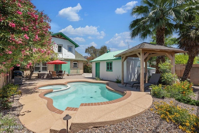 view of pool featuring an in ground hot tub, a gazebo, and a patio area