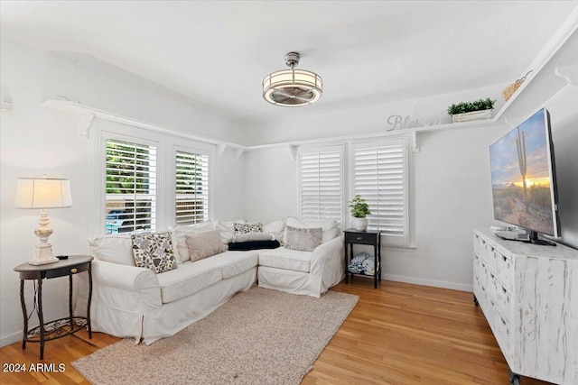 living area with baseboards and light wood-style flooring