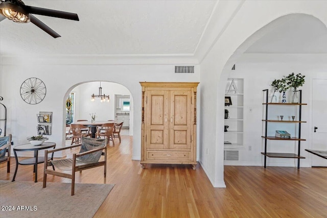 interior space featuring light wood-type flooring, built in features, and a textured ceiling