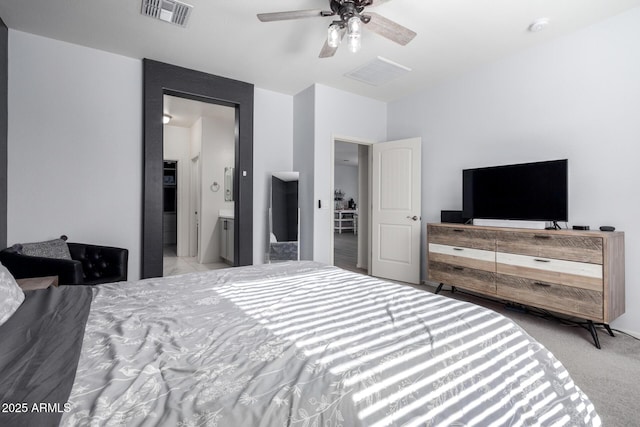 carpeted bedroom with ensuite bathroom and ceiling fan