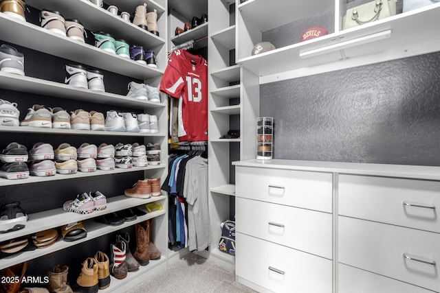 walk in closet featuring light colored carpet