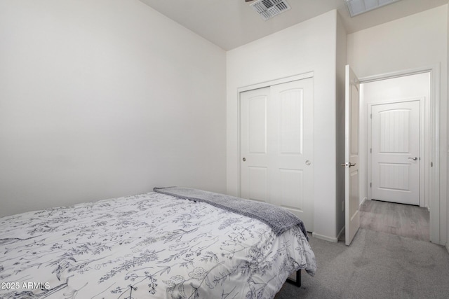 bedroom with light carpet and a closet