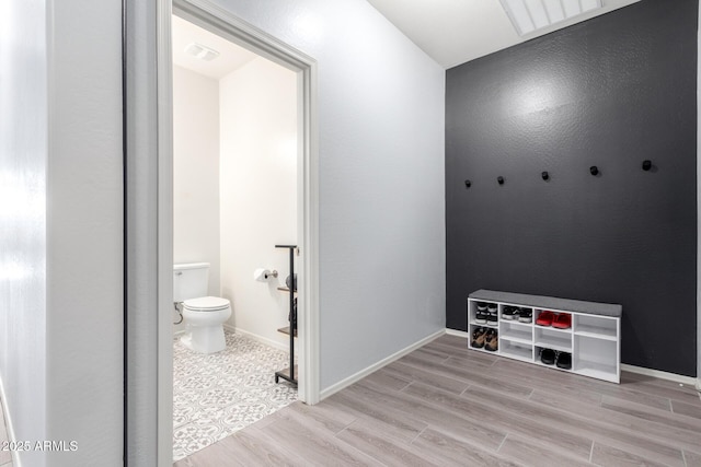 bathroom featuring wood-type flooring and toilet