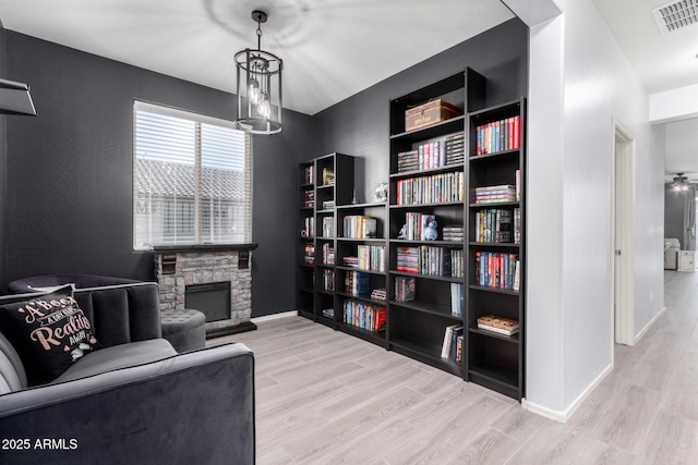 living area with light hardwood / wood-style flooring and a fireplace