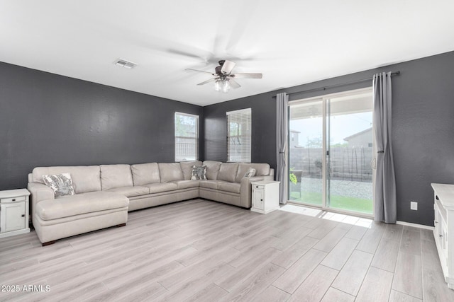 unfurnished living room with ceiling fan, light hardwood / wood-style flooring, and a healthy amount of sunlight