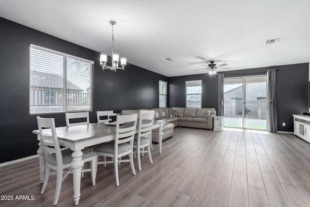 dining room with ceiling fan with notable chandelier