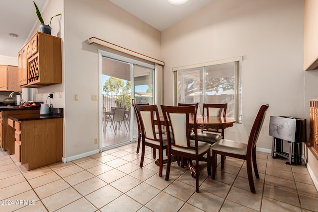 tiled dining room with lofted ceiling