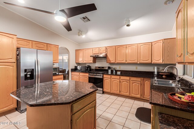 kitchen featuring stainless steel appliances, lofted ceiling, sink, a kitchen island, and dark stone countertops