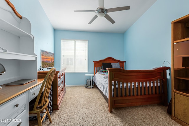 carpeted bedroom with ceiling fan and built in desk