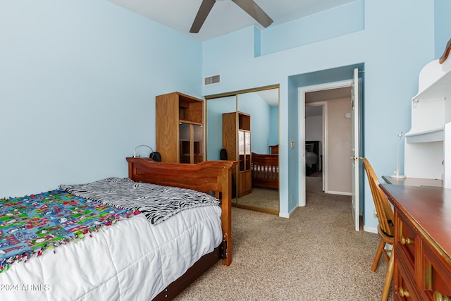 bedroom with a closet, light colored carpet, and ceiling fan