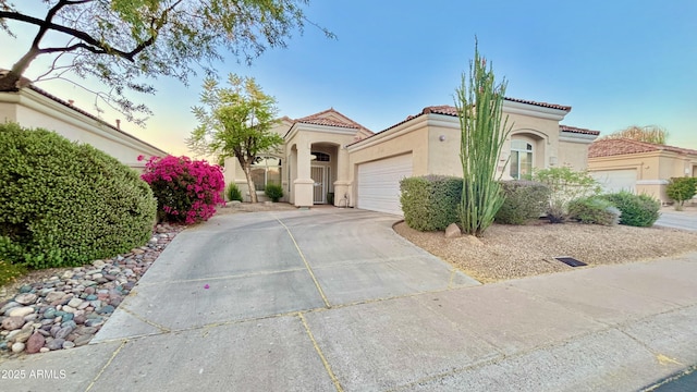 11854 E Carol Ave, Scottsdale, AZ 85259 - mediterranean / spanish home featuring stucco siding, driveway, an attached garage, and a tiled roof