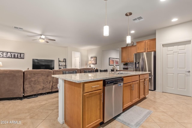 kitchen featuring sink, decorative light fixtures, an island with sink, and appliances with stainless steel finishes