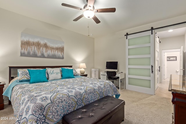 carpeted bedroom featuring ceiling fan and a barn door