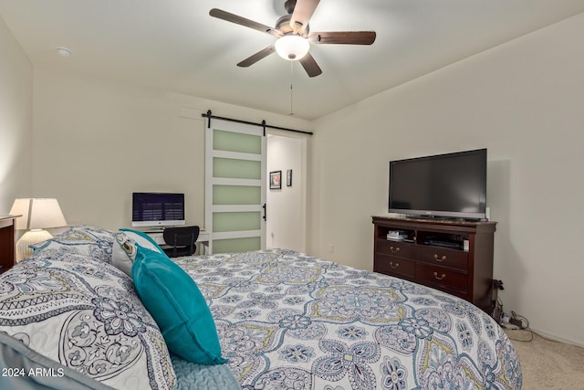 bedroom with light colored carpet, a barn door, and ceiling fan