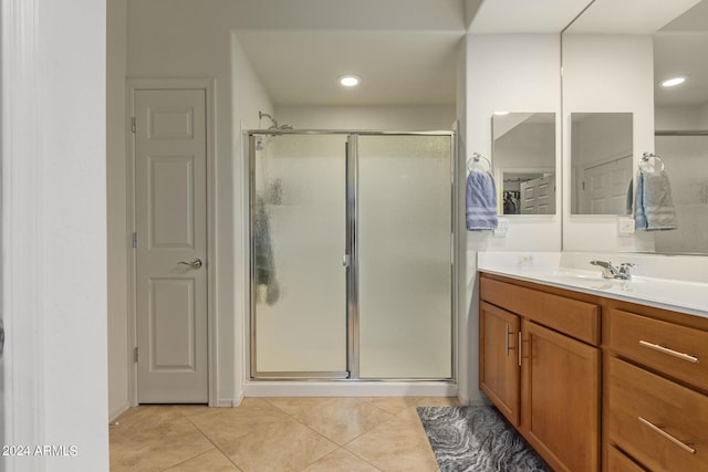 bathroom featuring walk in shower, vanity, and tile patterned flooring