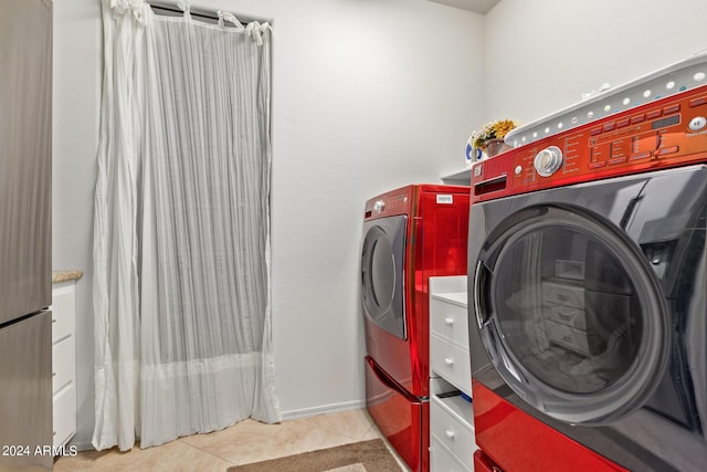 laundry room with light tile patterned floors and washer and clothes dryer