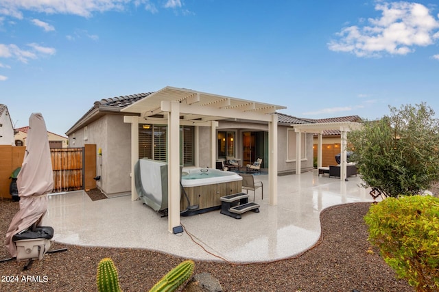 back of property featuring a hot tub, a pergola, and a patio area