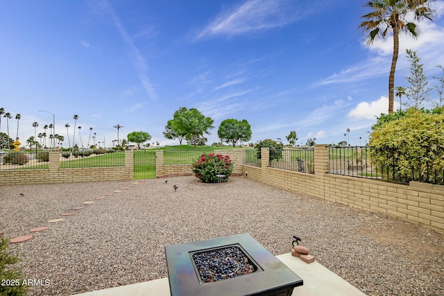 view of yard with a fenced backyard and an outdoor fire pit