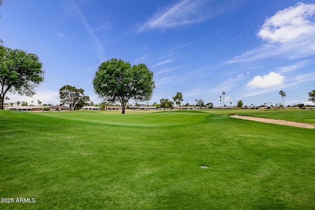 surrounding community with a yard and golf course view