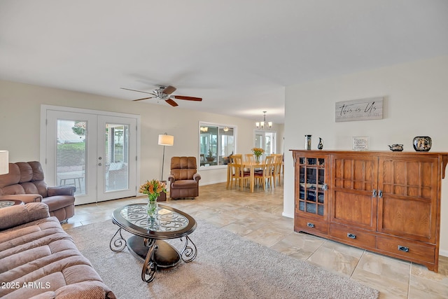 living room with ceiling fan with notable chandelier and french doors