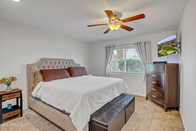 bedroom featuring stone finish floor, baseboards, and ceiling fan