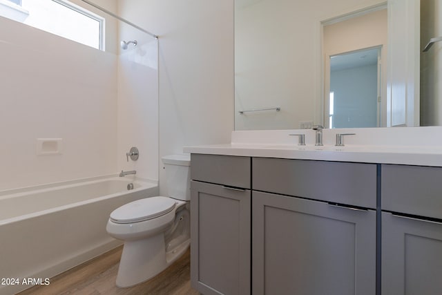 full bathroom featuring hardwood / wood-style flooring, vanity, bathtub / shower combination, and toilet