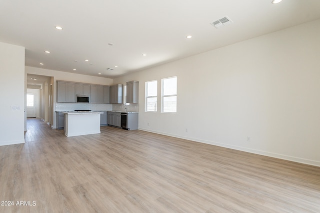 kitchen featuring gray cabinets, plenty of natural light, a center island, and light wood-type flooring