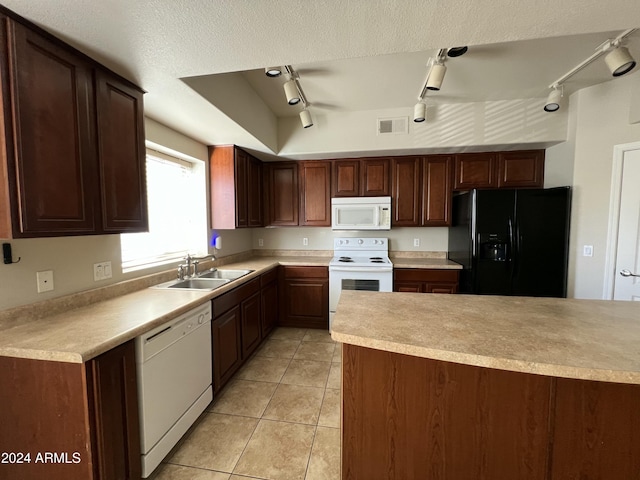 kitchen featuring track lighting, white appliances, a raised ceiling, sink, and light tile patterned floors