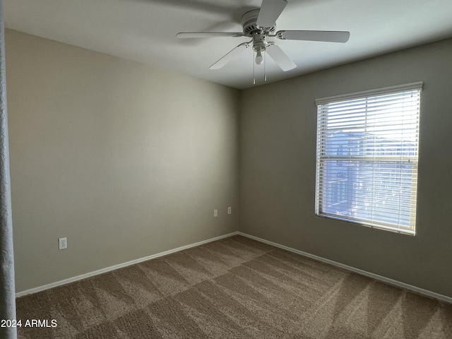 carpeted spare room featuring ceiling fan