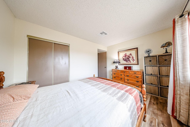 bedroom with wood finished floors, a closet, and a textured ceiling