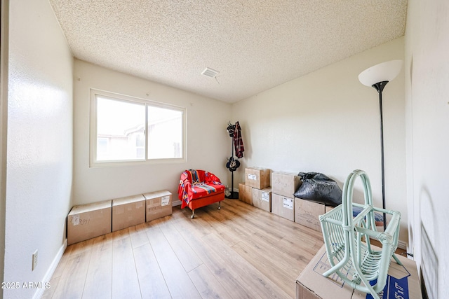living area featuring wood finished floors and a textured ceiling
