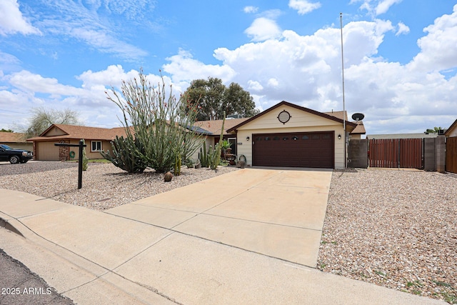 single story home with driveway, an attached garage, fence, and a gate