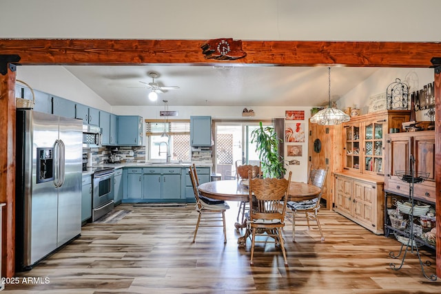 kitchen featuring stainless steel appliances, blue cabinetry, light wood-style floors, and ceiling fan