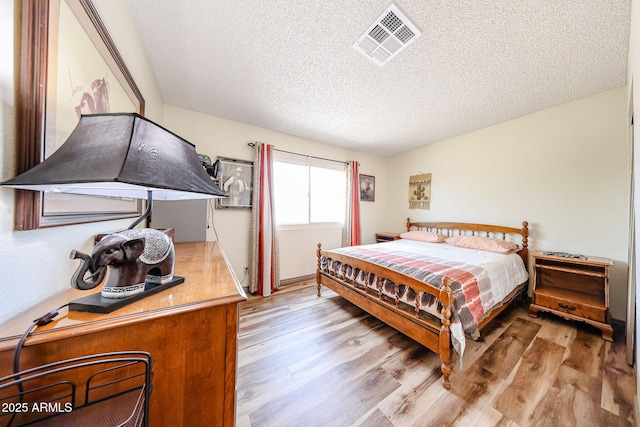 bedroom with wood finished floors and a textured ceiling