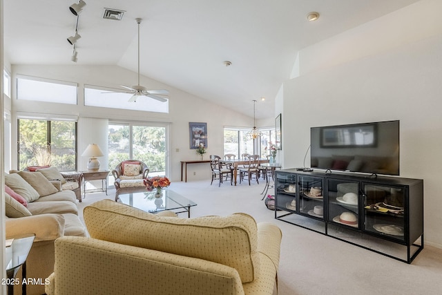 carpeted living room with ceiling fan, track lighting, and high vaulted ceiling