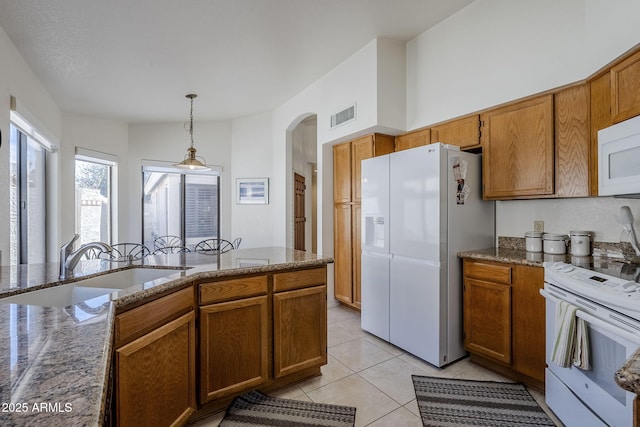 kitchen featuring pendant lighting, white appliances, light tile patterned flooring, and sink