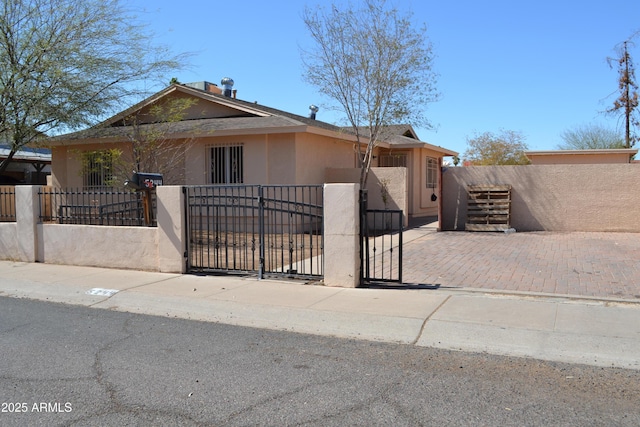 view of front of house featuring a gate, a fenced front yard, and stucco siding