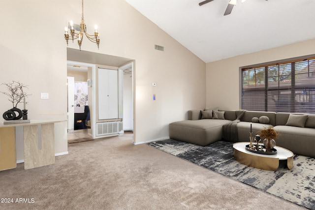 carpeted living room with ceiling fan with notable chandelier and high vaulted ceiling