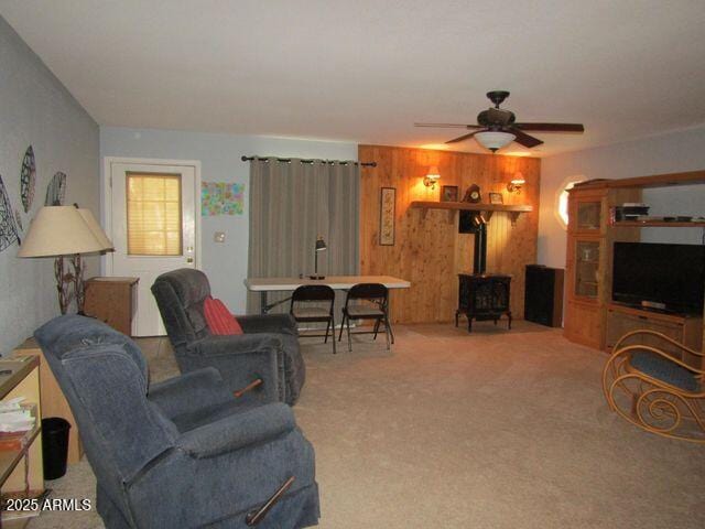 2007 N Murchison Cir, Payson, AZ 85541 - carpeted living room featuring a wood stove, a ceiling fan, and wood walls