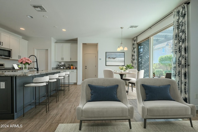 interior space featuring light hardwood / wood-style floors, a notable chandelier, and sink