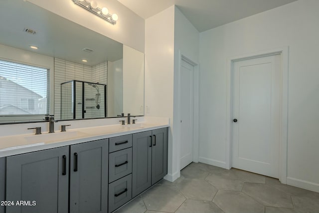 bathroom with tile patterned flooring, vanity, and walk in shower