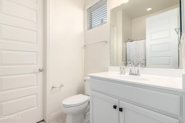 bathroom with toilet, vanity, and walk in shower