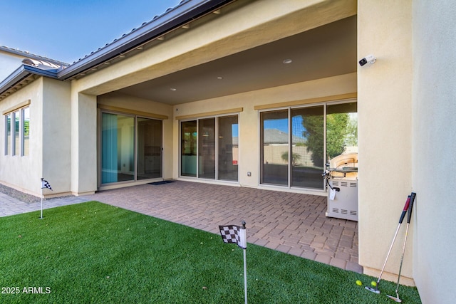 rear view of house featuring a lawn and a patio