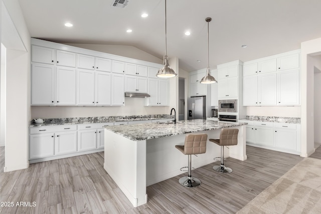 kitchen featuring white cabinetry, appliances with stainless steel finishes, and a kitchen island with sink