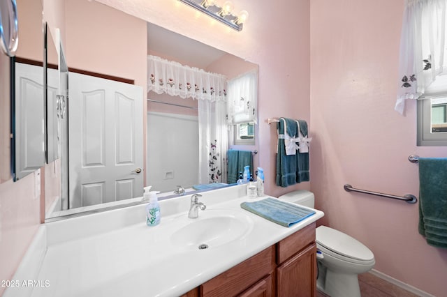 bathroom featuring vanity, tile patterned flooring, toilet, and curtained shower