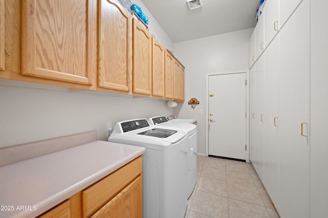 laundry room featuring separate washer and dryer, light tile patterned flooring, cabinet space, and visible vents