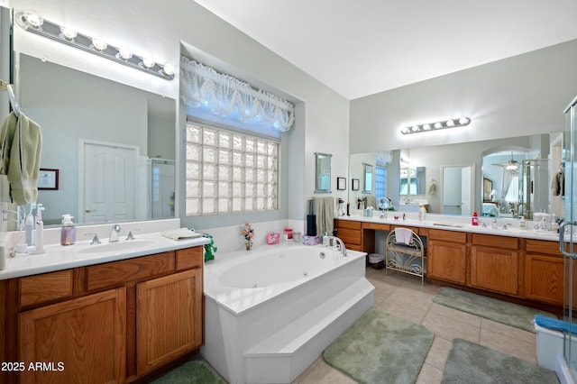 full bath featuring ceiling fan, a sink, two vanities, a tub with jets, and a stall shower
