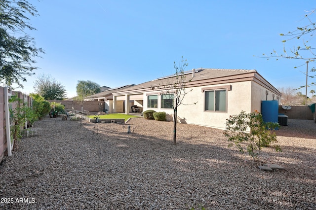 back of property featuring a fenced backyard, central AC unit, and stucco siding