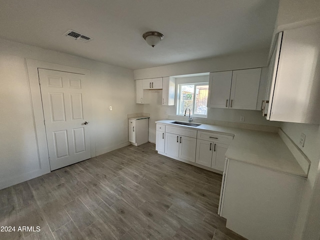 kitchen featuring white cabinets, light hardwood / wood-style flooring, and sink